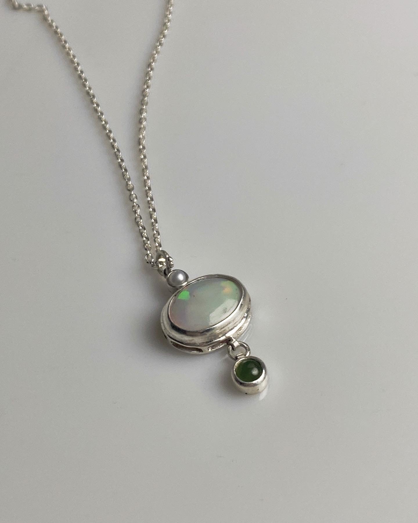 Opal pendant with a small pearl and a jade charm